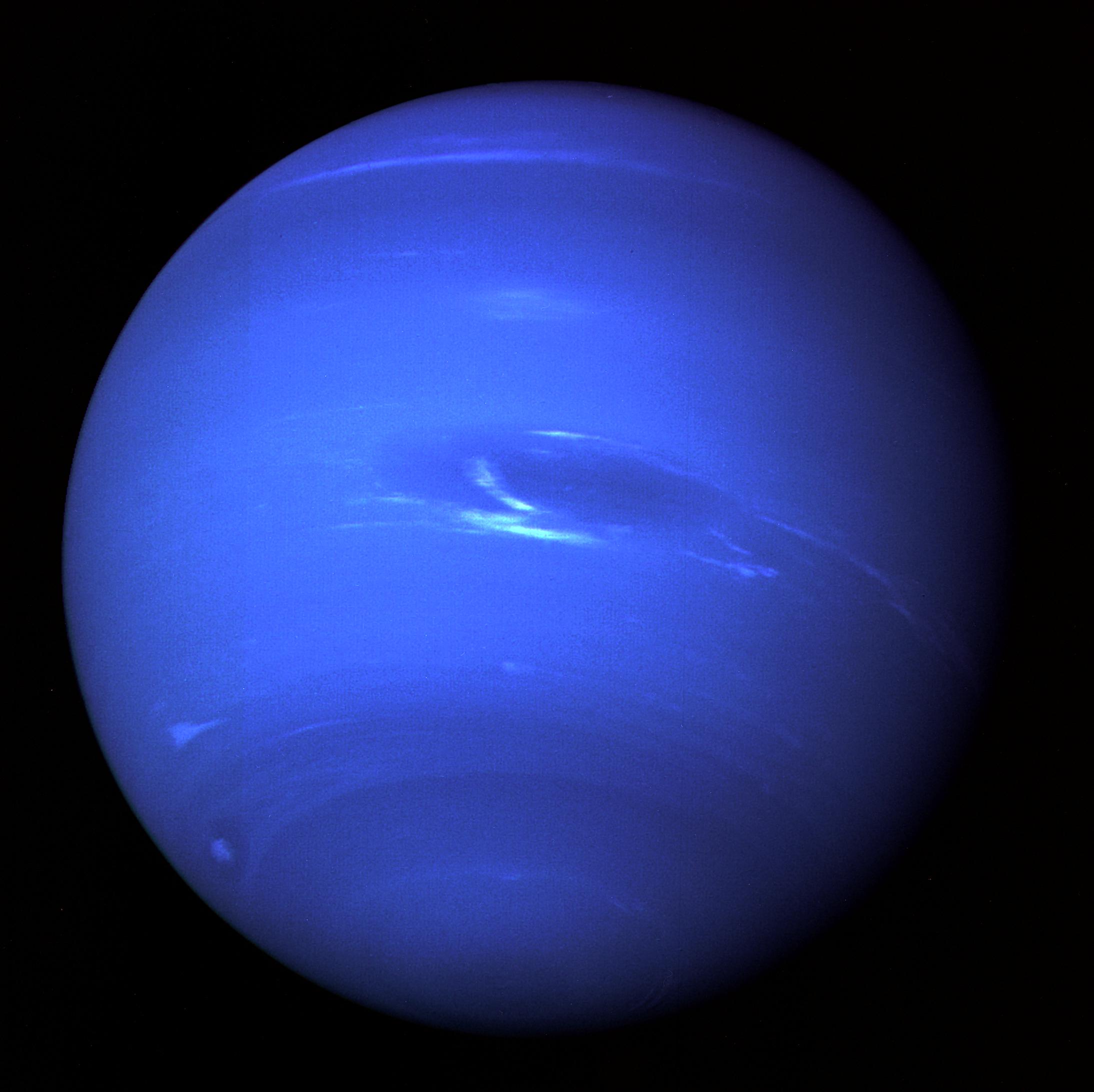 Neptune full disk photographed by Voyager 2 in 1989, deep blue with the Great Dark Spot. NASA/JPL.