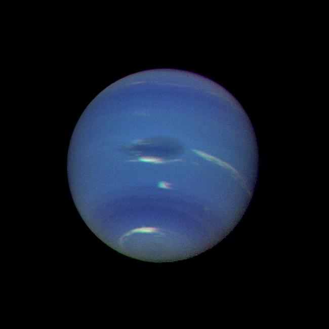 Neptune's blue-green atmosphere showing the Great Dark Spot, imaged by Voyager 2 in 1989.