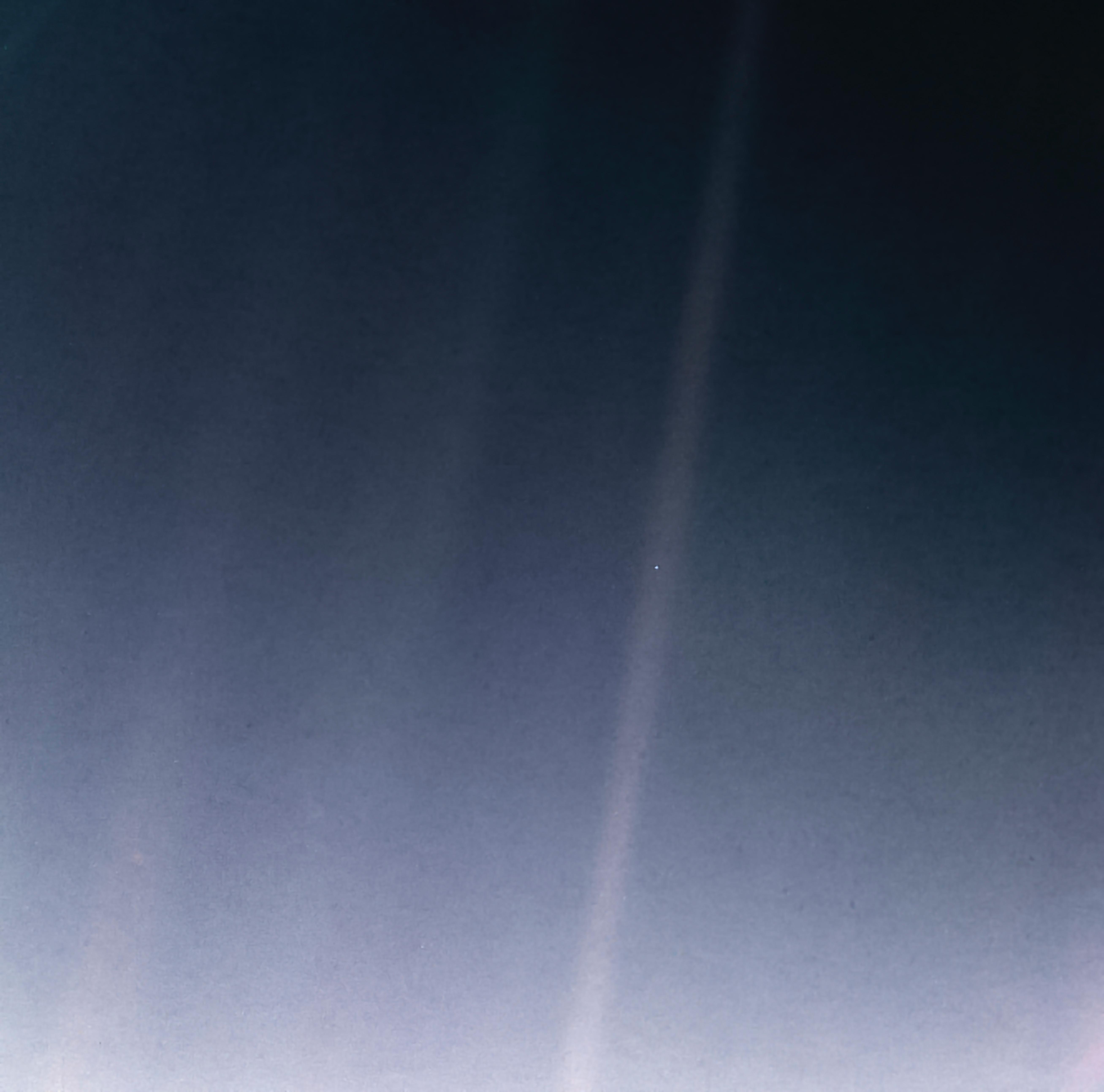 The Pale Blue Dot — Earth as a tiny point of light photographed by Voyager 1 from 6 billion kilometers away.