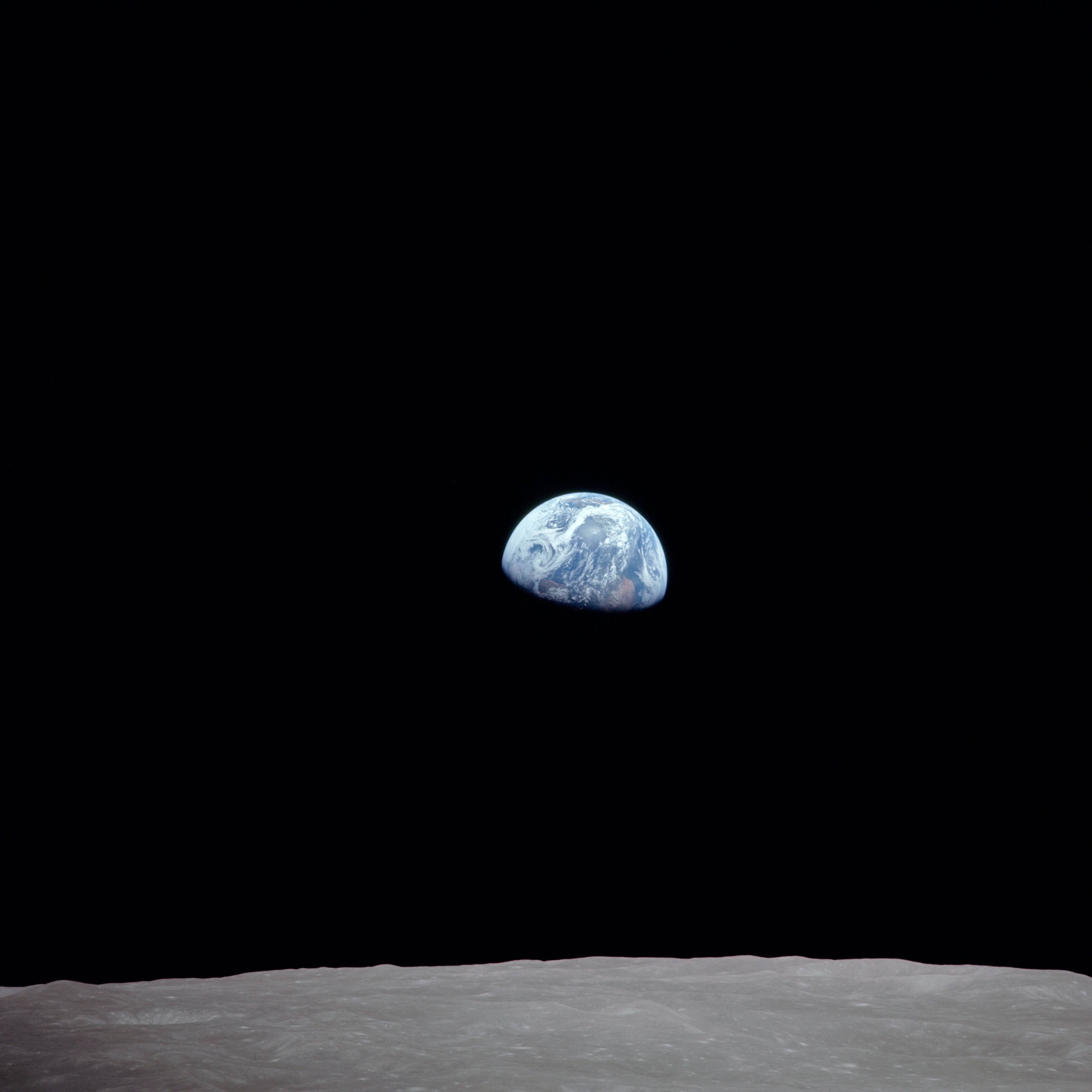 Earthrise rotated to conventional Earth-up orientation showing blue planet above gray Moon surface.