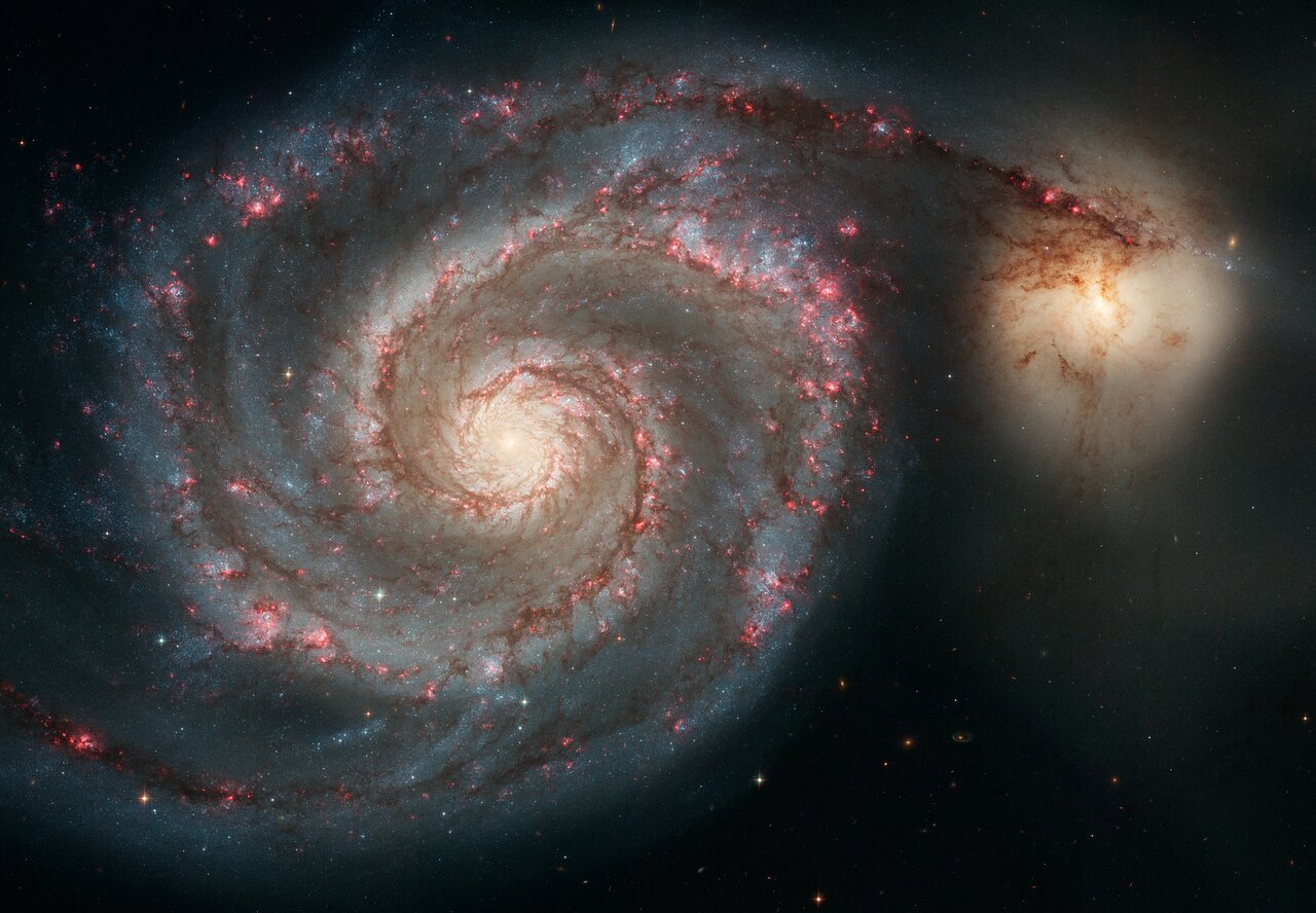 The Whirlpool Galaxy M51 — Hubble Space Telescope Advanced Camera for Surveys image showing the grand-design spiral arms in blue and pink with dust lanes, and the smaller companion galaxy NGC 5195 at the top.